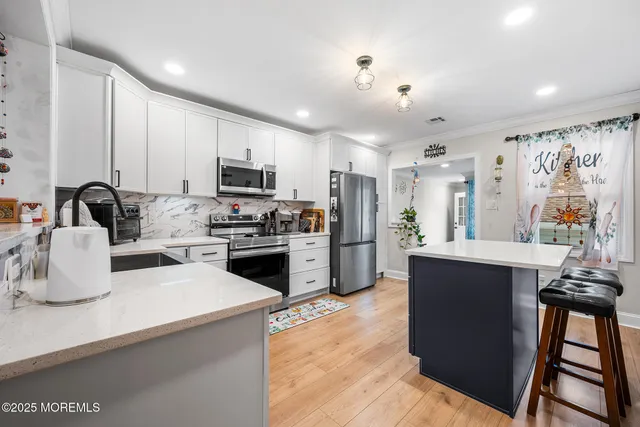 a kitchen with granite countertop a refrigerator stove and sink