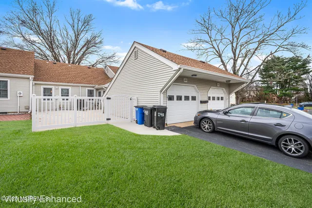 a view of a white house in a back yard