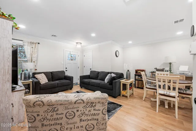 a living room with furniture a flat screen tv and kitchen view