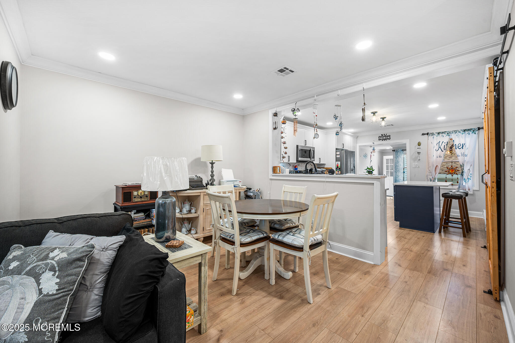 24 Calle De Elvira, Unit B Freehold, NJ 07728 - Photo 10 of 25 a kitchen with stainless steel appliances kitchen island granite countertop a sink a stove a dining table and chairs