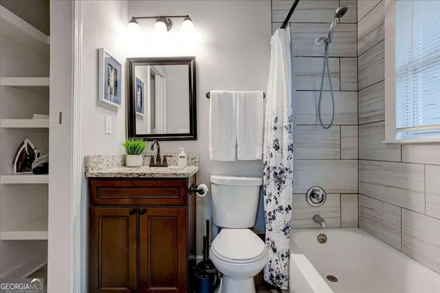 a bathroom with a granite countertop toilet sink and mirror