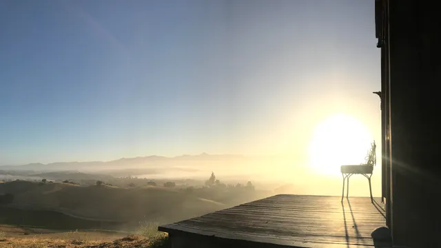 a bedroom with a bed next to a window with wooden floor