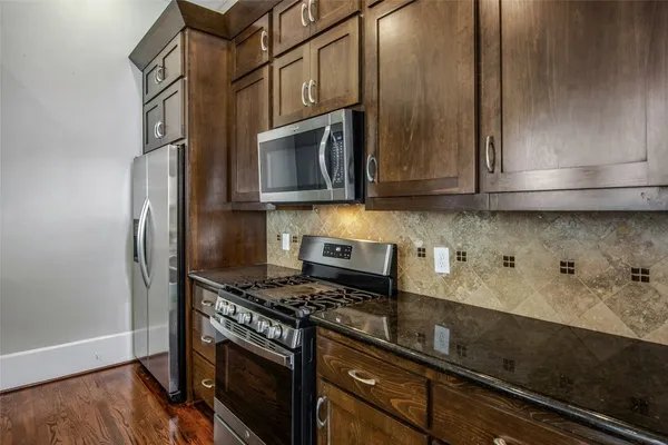 a kitchen with stainless steel appliances granite countertop a stove and a microwave