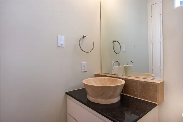 a bathroom with a granite countertop sink and a mirror