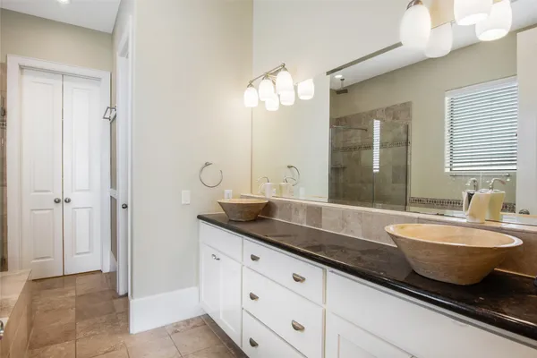 a spacious bathroom with a granite countertop sink mirror and bathtub
