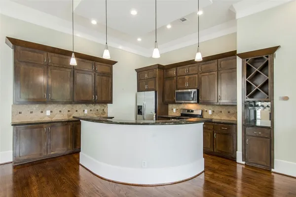 a kitchen with stainless steel appliances granite countertop a sink a stove and a refrigerator