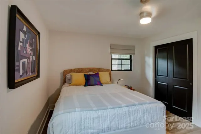 a bedroom with a large bed and a chandelier