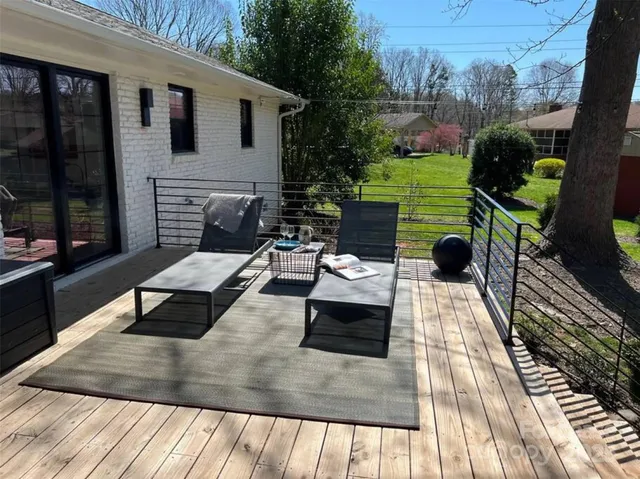 a view of a patio with table and chairs with wooden floor and fence