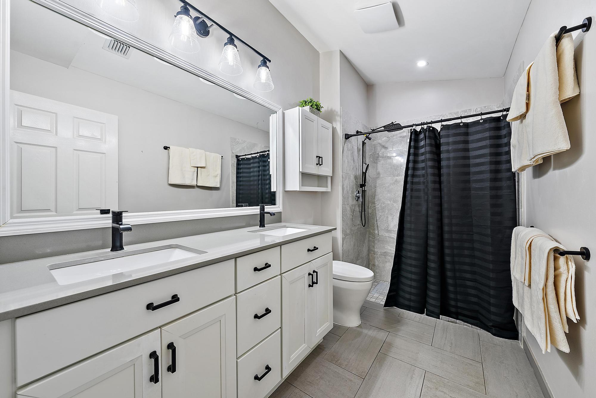 112 Spoonbill Court Jupiter, FL 33458 - Photo 13 of 28 a bathroom with a double vanity sink toilet and shower