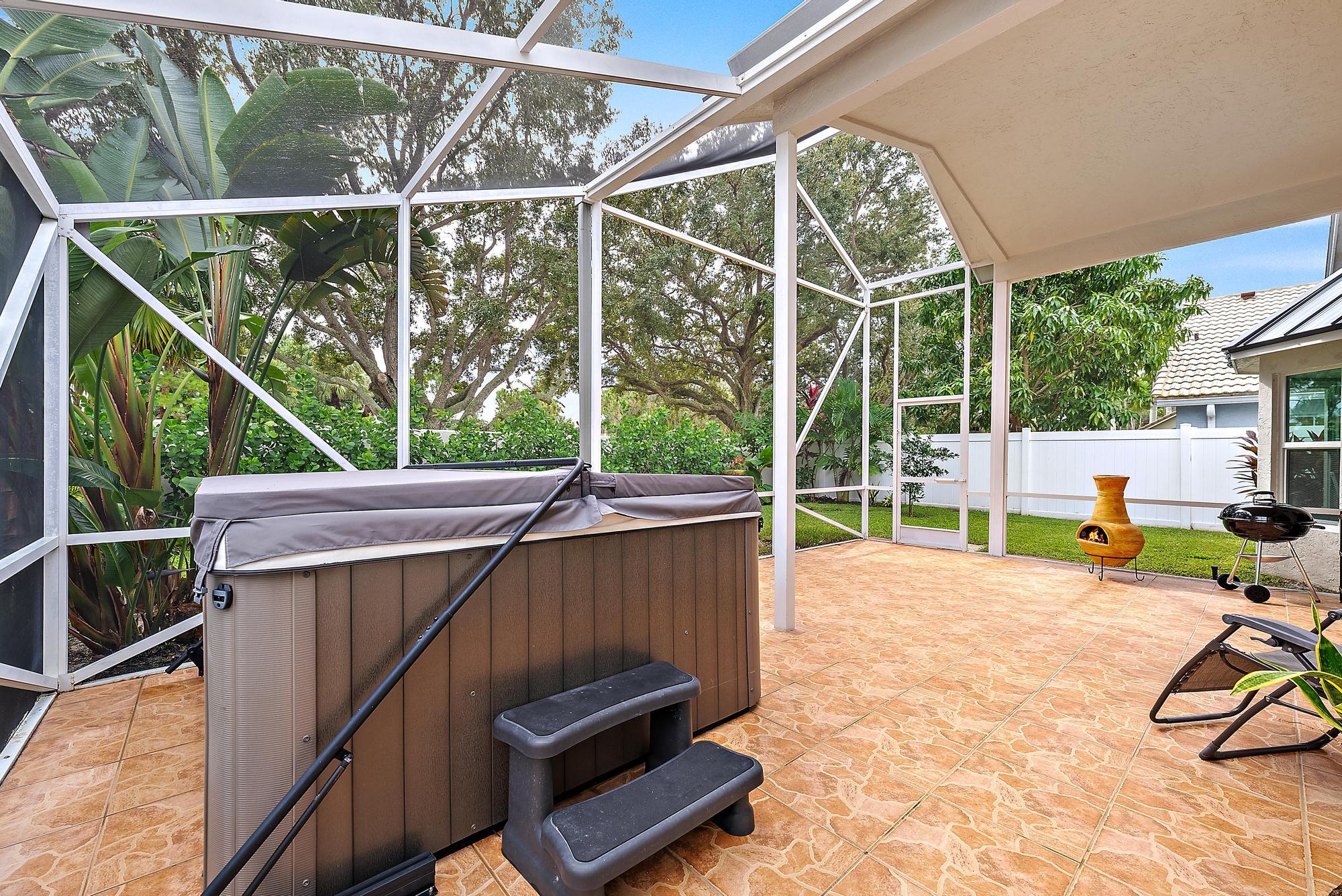 112 Spoonbill Court Jupiter, FL 33458 - Photo 20 of 28 a view of a patio with a table chairs and a yard