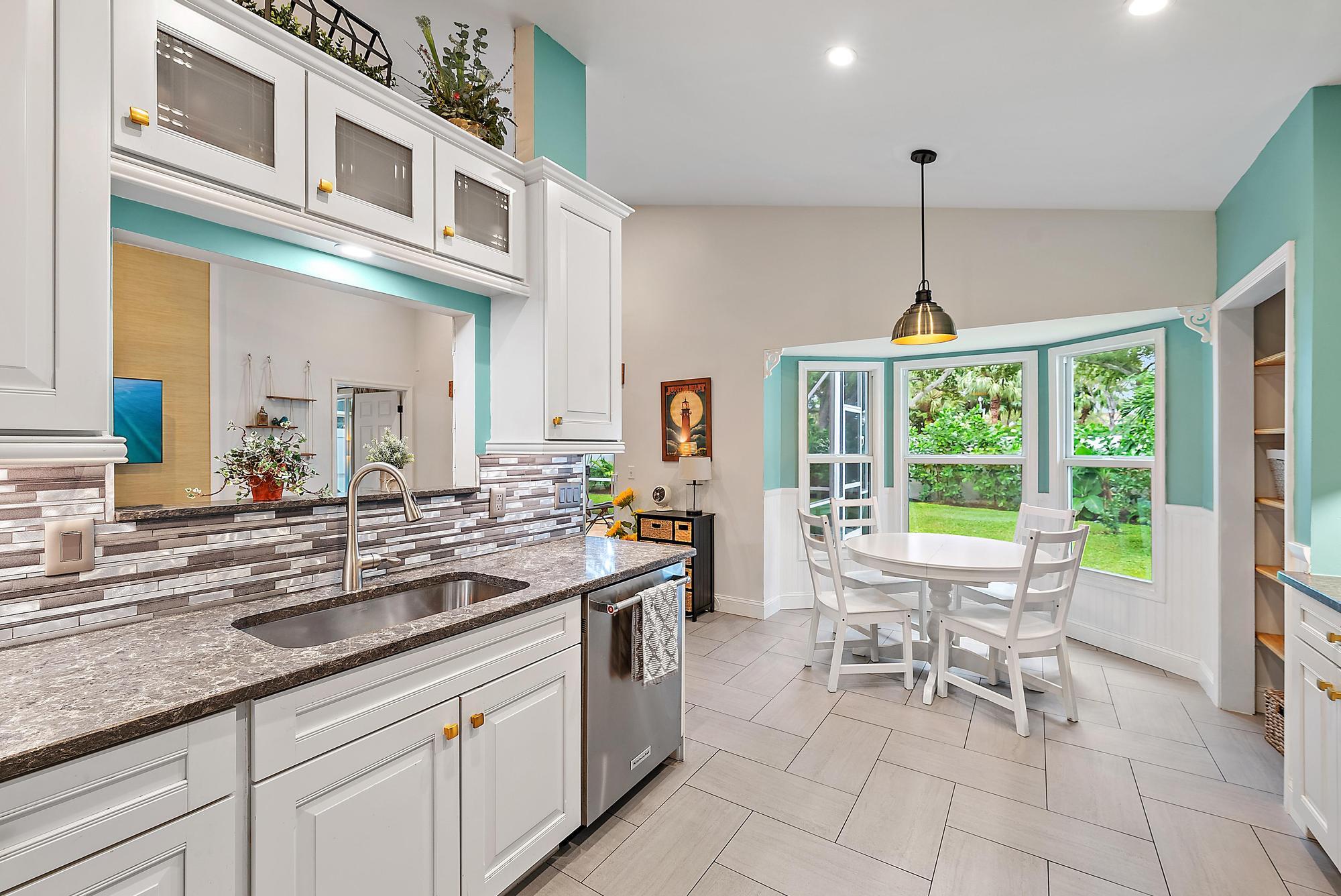 112 Spoonbill Court Jupiter, FL 33458 - Photo 5 of 28 a kitchen with stainless steel appliances granite countertop a sink and a view of living room