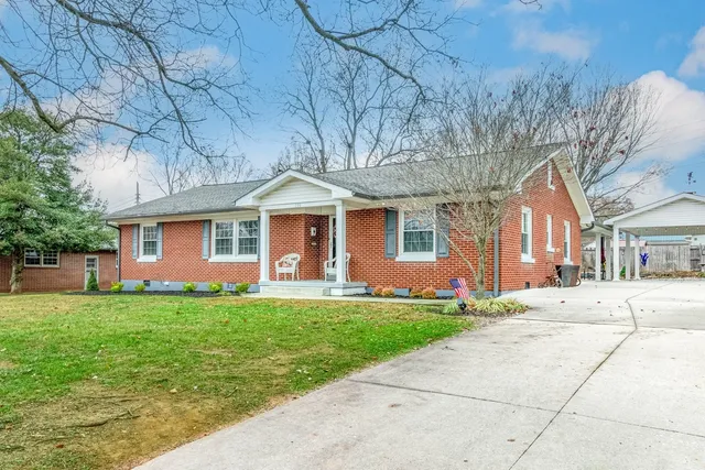 a front view of a house with a yard and trees