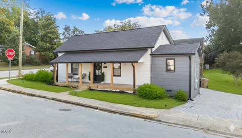 a view of a house with a yard and tree s