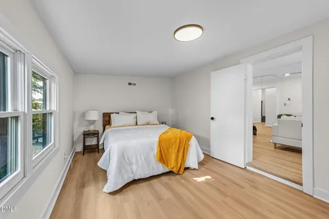 a bed sitting in a bedroom next to a window