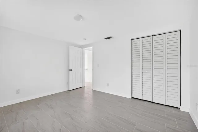 a backyard of a house with a barn plants and large tree