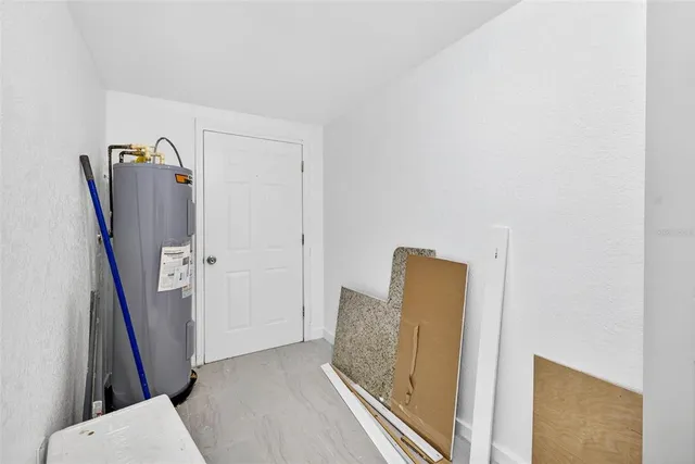 a view of empty room with wooden floor and kitchen