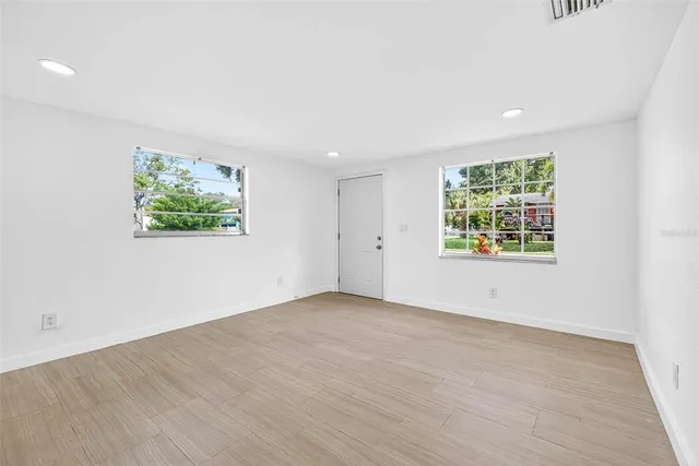 an empty room with wooden floor and white walls