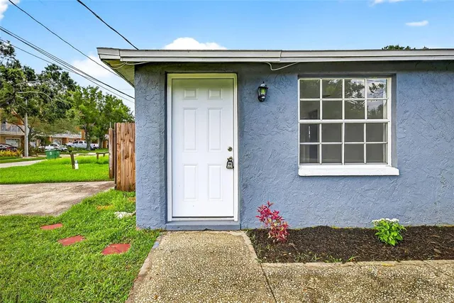 a view of an empty room with kitchen and a sink