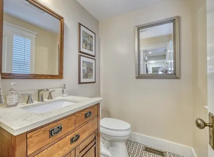 a bathroom with a granite countertop toilet sink and mirror