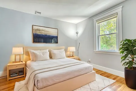 a bedroom with a bed and a potted plant