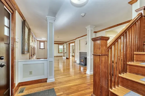 a view of a hallway with wooden floor and entryway