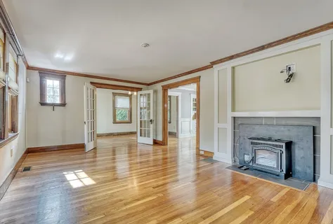 a view of a livingroom with wooden floor and a fireplace