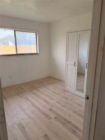 an empty room with windows and closet