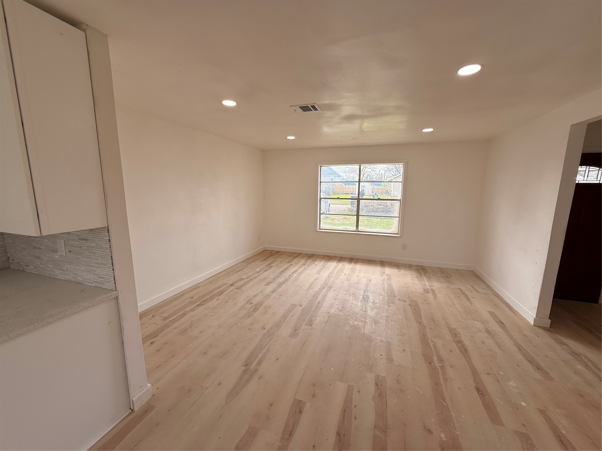 8015 Howton Street Houston, TX 77028 - Photo 7 of 11 an empty room with wooden floor and windows