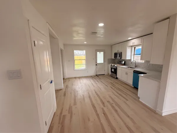 a view of a kitchen counter space wooden floor and stainless steel appliances