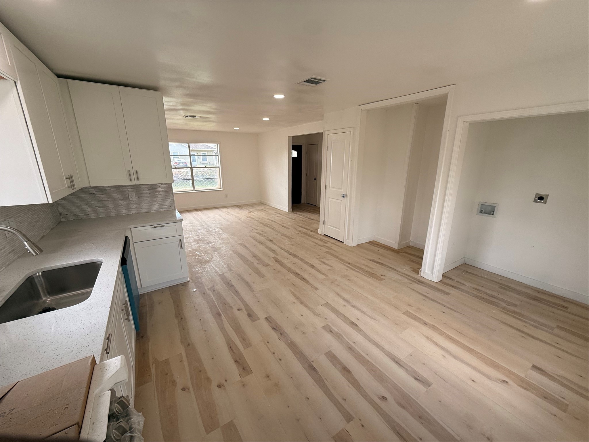 8015 Howton Street Houston, TX 77028 - Photo 10 of 11 a view of kitchen and empty room with wooden floor