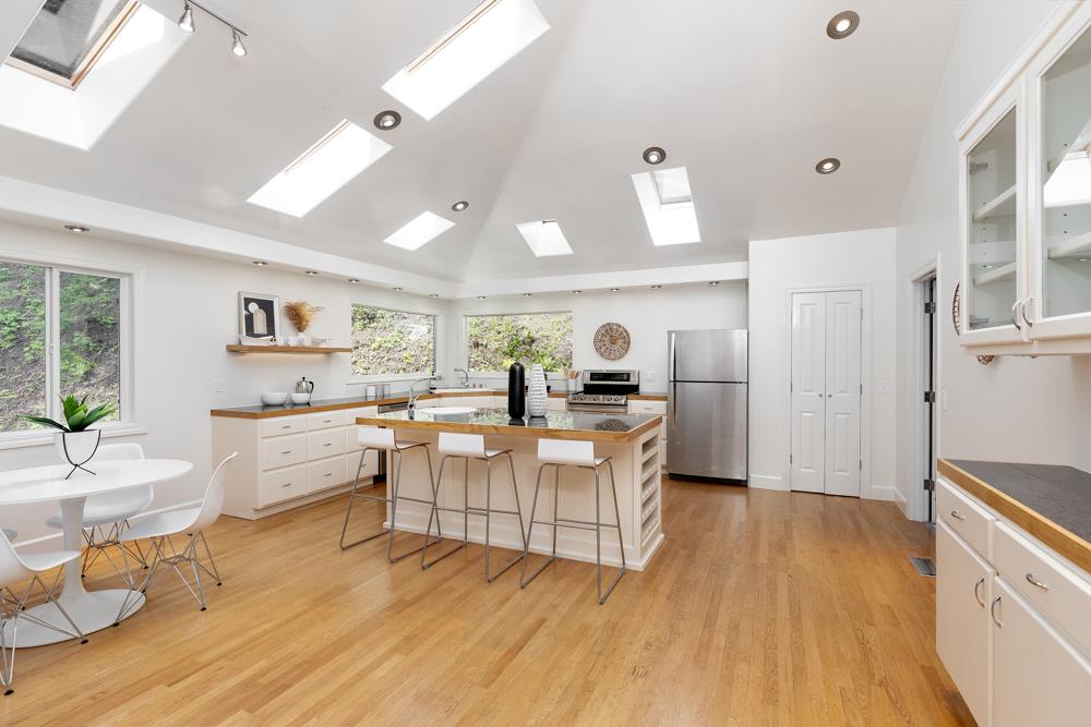4399 Porter Gulch Road Aptos, CA 95003 - Photo 5 of 32 a large white kitchen with a large window a refrigerator and a stove