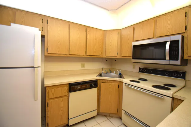 a kitchen with stainless steel appliances a refrigerator stove top oven and cabinets