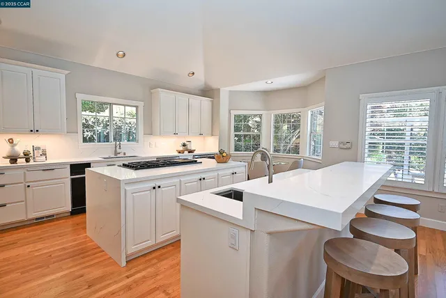 a kitchen with a stove a sink a dining table and chairs