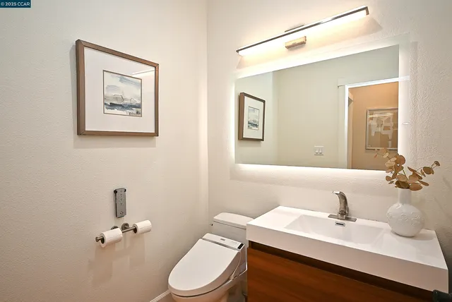 a bathroom with a sink mirror and toilet