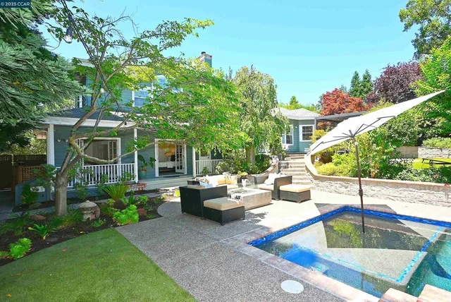 a view of a patio with table and chairs potted plants and floor to ceiling window and wooden fence