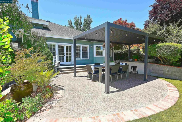 a view of a chair and table in backyard of a house