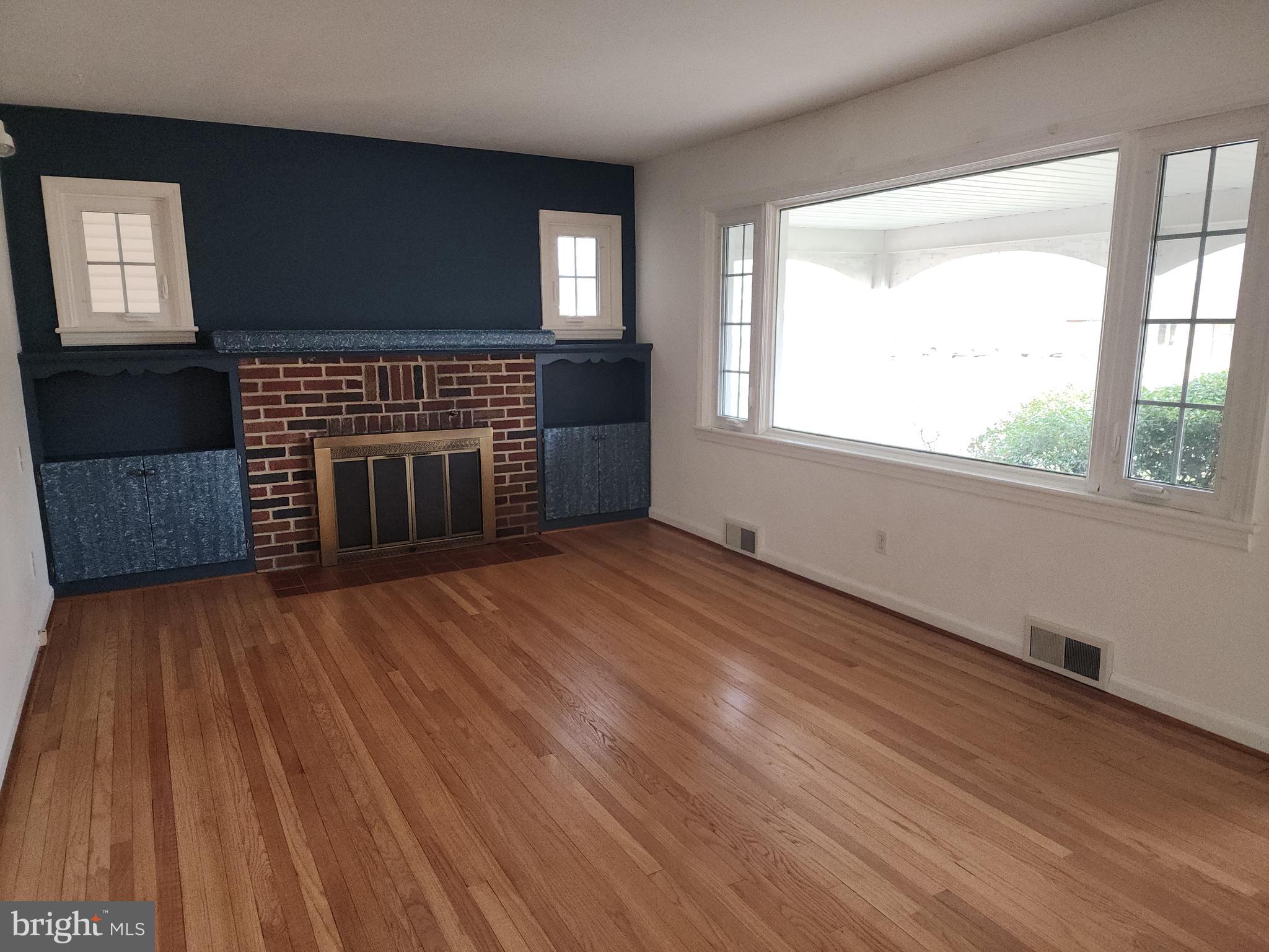 405 Beaumont Road York, PA 17403 - Photo 8 of 30 an empty room with wooden floor a fireplace and windows