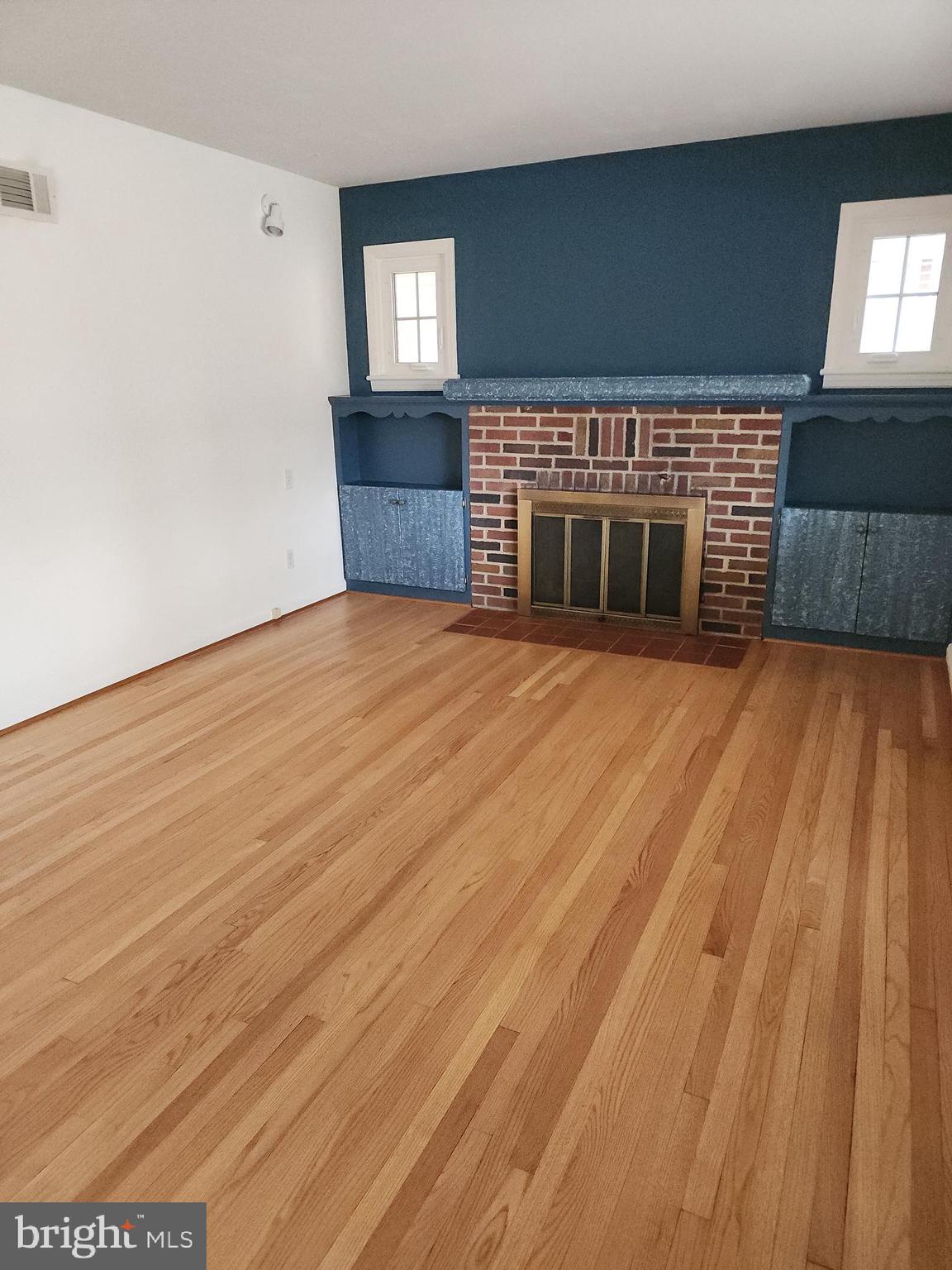 405 Beaumont Road York, PA 17403 - Photo 9 of 30 an empty room with wooden floor fireplace and windows