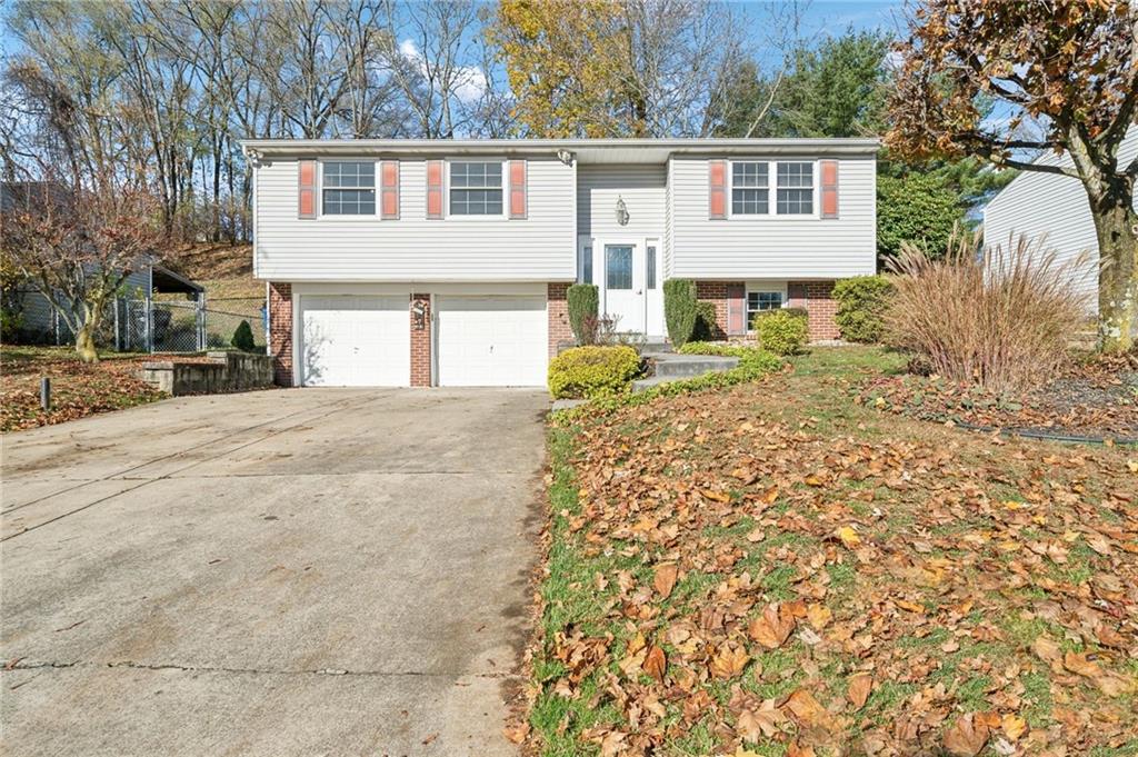 a view of a house with a yard and large tree