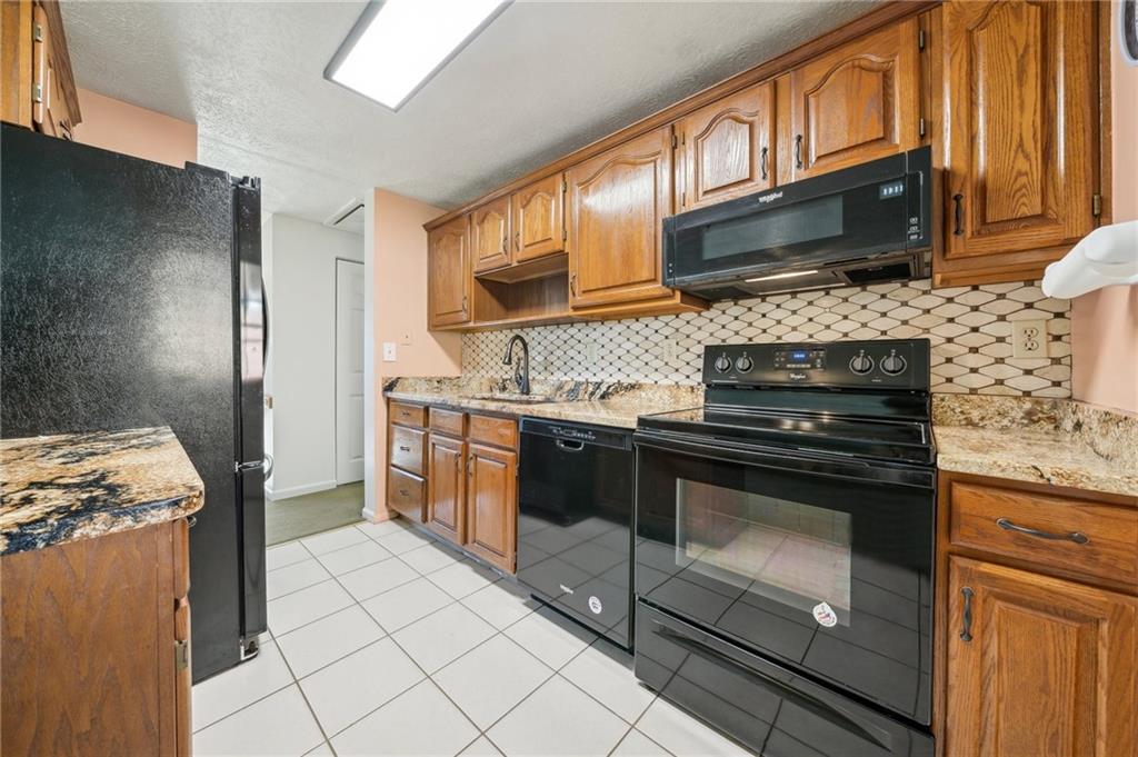 1828 Ivanhoe Drive Irwin, PA 15642 - Photo 6 of 33 a kitchen with stainless steel appliances granite countertop a stove microwave and sink