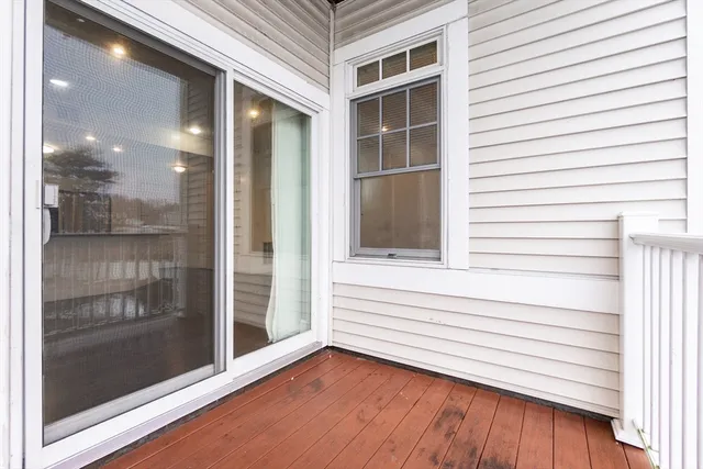 a view of a balcony with floor to ceiling windows and kitchen