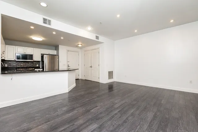 a view of kitchen with stainless steel appliances a refrigerator and a stove top oven