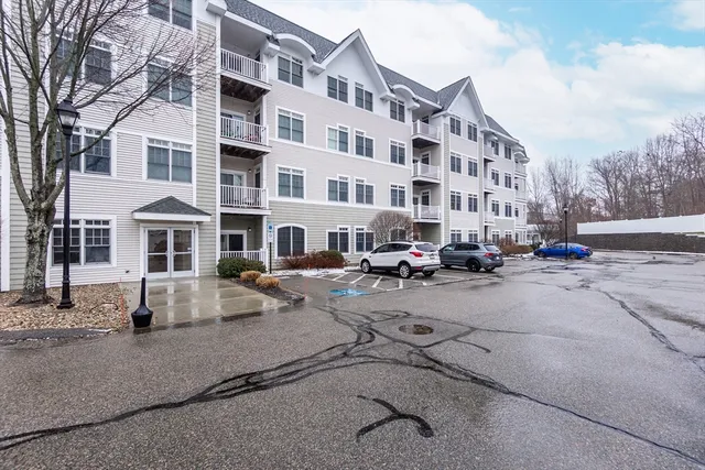a front view of a building with lot of cars parked