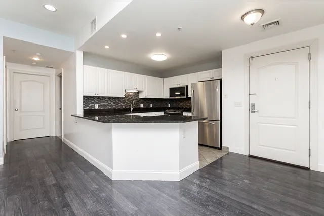 a kitchen with stainless steel appliances granite countertop a refrigerator and a stove top oven