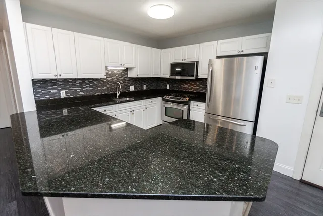a kitchen with stainless steel appliances granite countertop a refrigerator a stove a sink and a granite counter tops