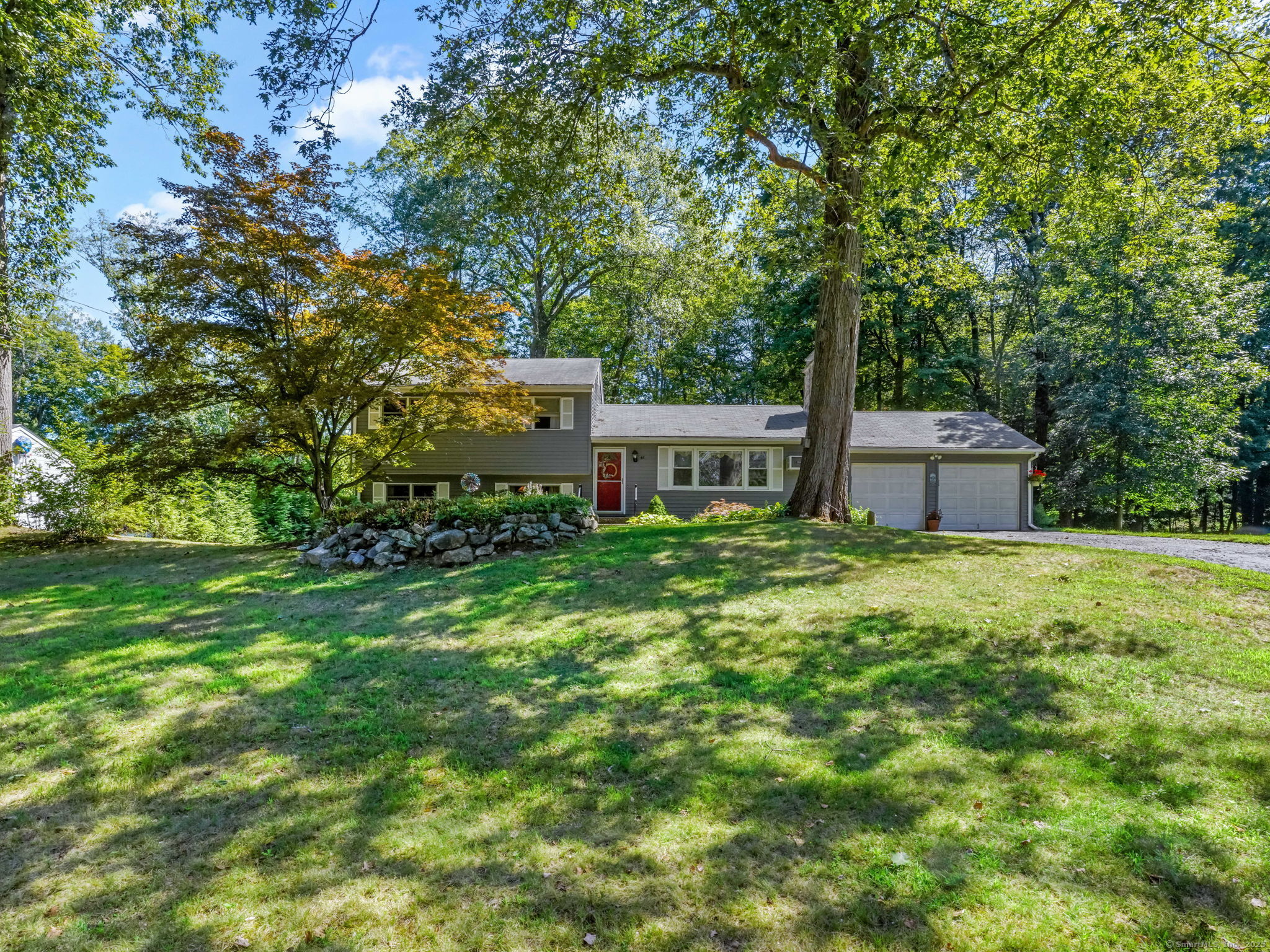 a front view of a house with a garden and yard