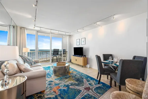 a living room with furniture a flat screen tv and a large window