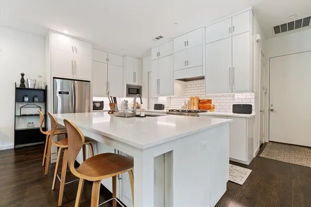 a kitchen with stainless steel appliances a refrigerator and a stove top oven