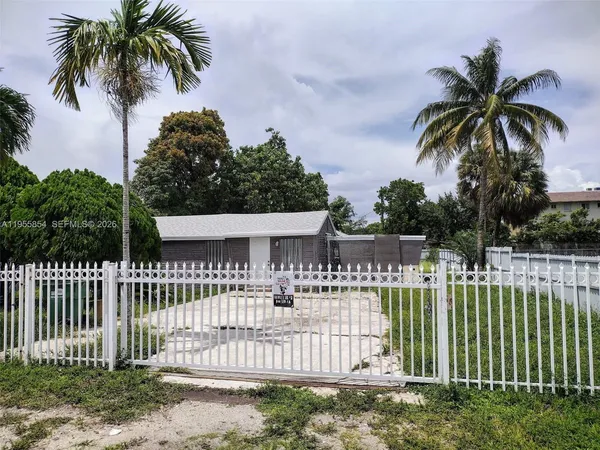 a front view of a house with a garden and plants