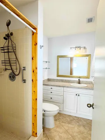 a bathroom with a granite countertop sink toilet and shower